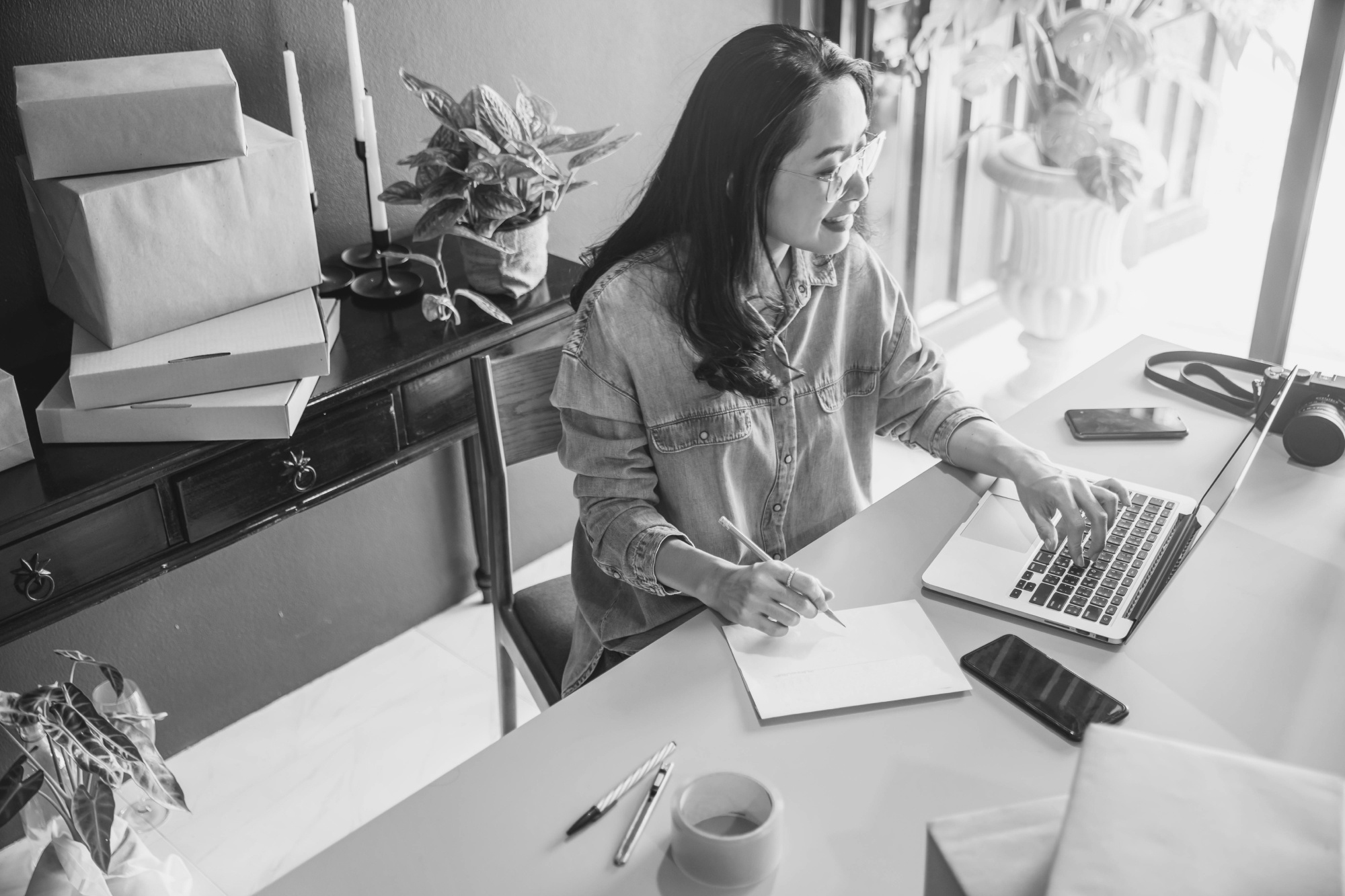 Woman on a laptop doing ecommerce admin work BW